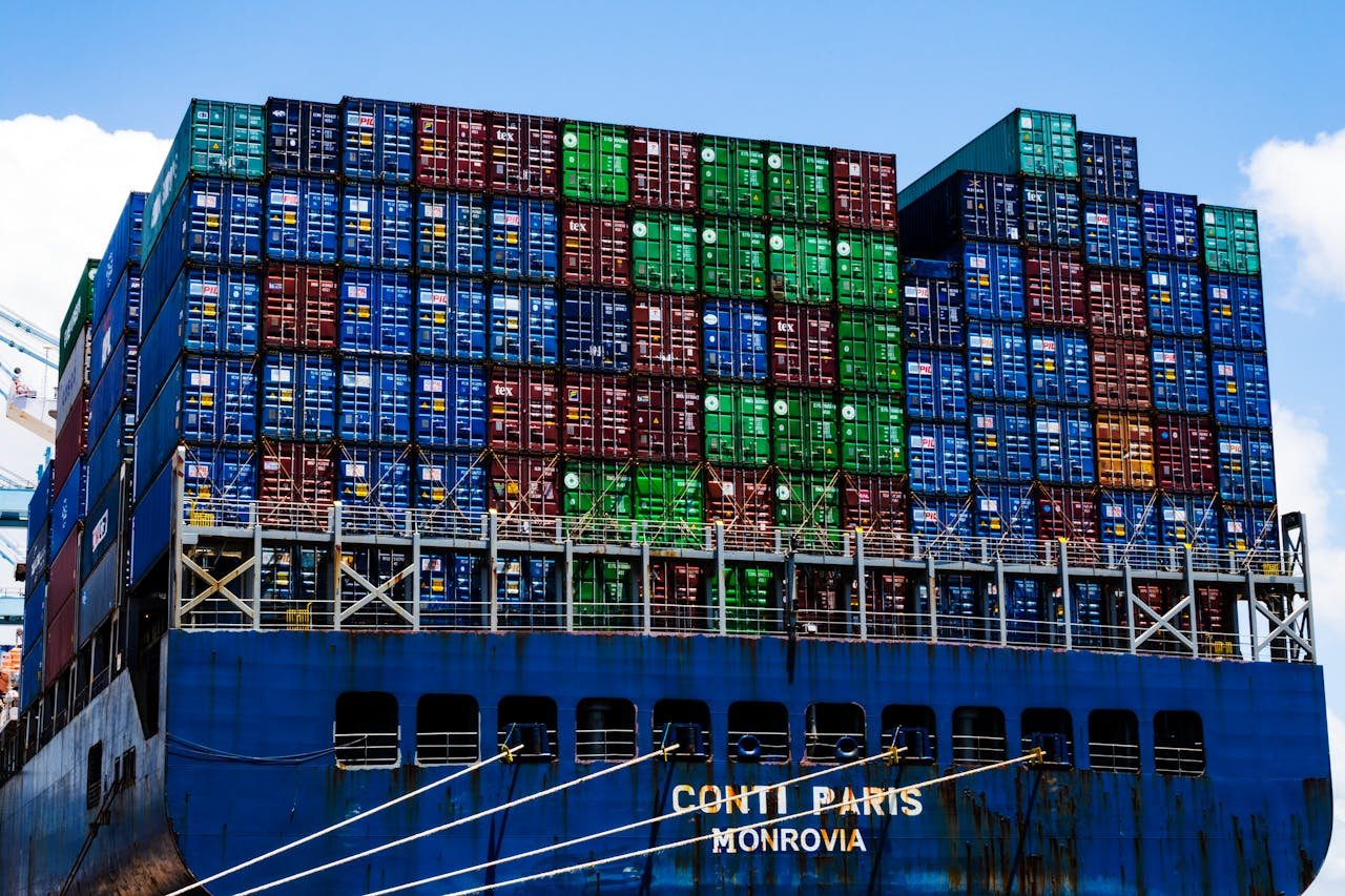 Insights Stacked cargo containers on a massive ship at the harbor, symbolizing global trade.